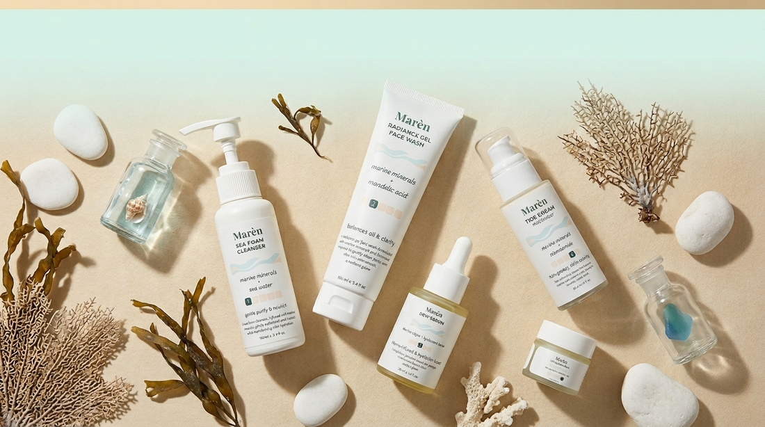 Five Marèn skincare products flat lay — Sea Foam Cleanser, Radiance Gel Face Wash, Dew Serum, Tide Cream, and Lip Quench Balm — arranged on a sandy surface with ocean-inspired props